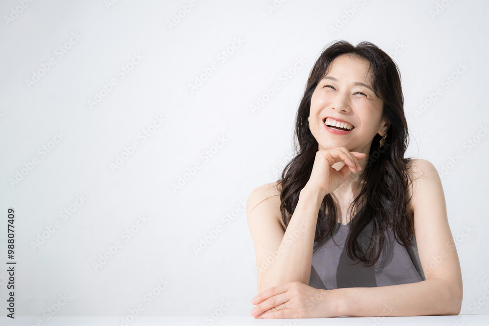 A beautiful 50-something woman with a cheeky smile for images such as beauty looking up thinking A beautiful 50-something woman with a cheeky smile for images such as beauty looking up thinking