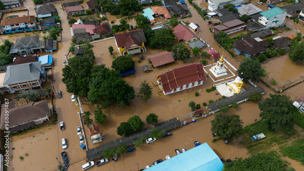 Fototapeta premium Aerial view of suburb area in Chiang Rai downtown flooding by Kok river after typhoon Yagi has swept Southeast Asia.