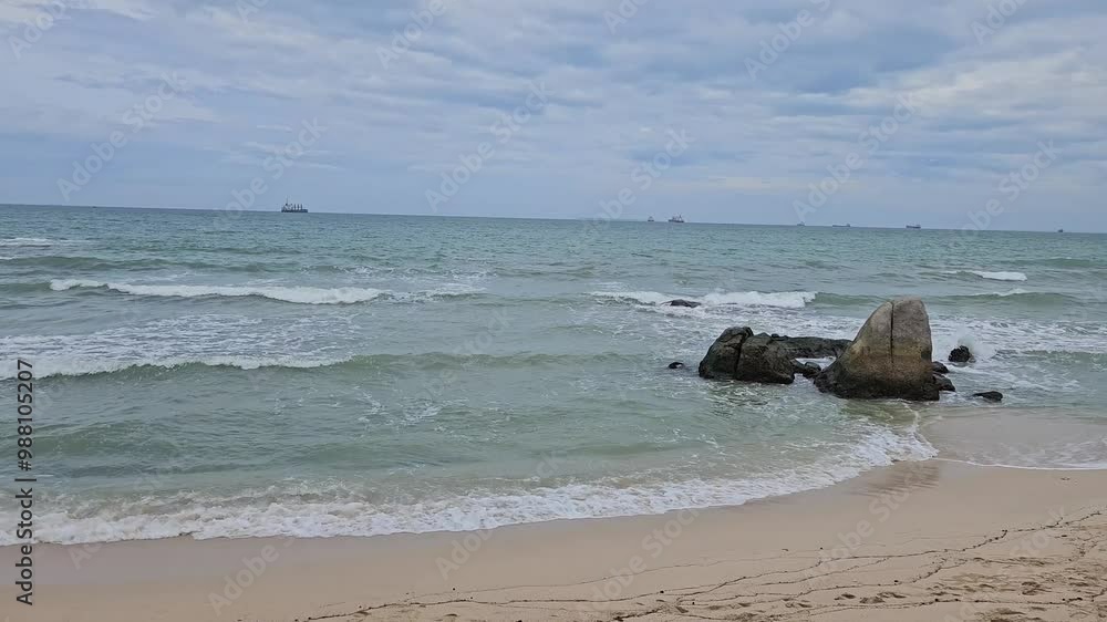 Sea waves splash and foam on beautiful sand beach of Ca Na, Ninh Thuan province, Vietnam. Waves break and crash on rocks and sand in a clear day. Sea waves splash and foam on beautiful sand beach of Ca Na, Ninh Thuan province, Vietnam. Waves break and crash on rocks and sand in a clear day.