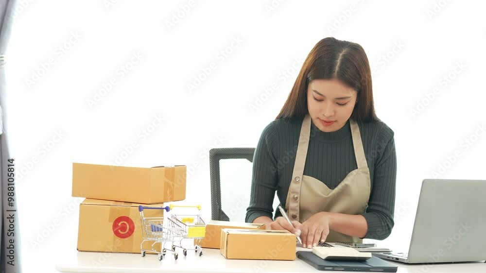 Female SME business owner entrepreneur working on receipt boxes and checking online orders to prepare to pack boxes, sell to customers. Online SME business concept, small business startup. Female SME business owner entrepreneur working on receipt boxes and checking online orders to prepare to pack boxes, sell to customers. Online SME business concept, small business startup.