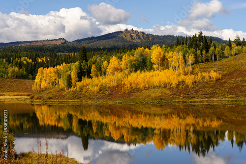 Yellow aspen trees with reflection in a lake and Rabbit ears rock formation in the background, Steamboat Springs Colorado