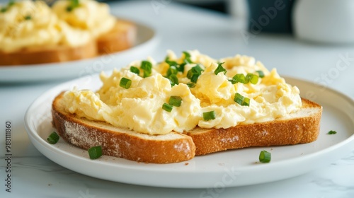 Scrambled eggs served on toasted bread, garnished with green onions, showcasing a delightful breakfast dish. photo