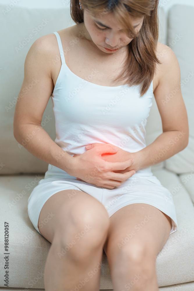 woman having abdomen ache due to Stomach pain, digestion with constipation or Diarrhea from food poisoning, female problem and Endometriosis, Hysterectomy, Stomachache and Menstrual on sofa at home woman having abdomen ache due to Stomach pain, digestion with constipation or Diarrhea from food poisoning, female problem and Endometriosis, Hysterectomy, Stomachache and Menstrual on sofa at home