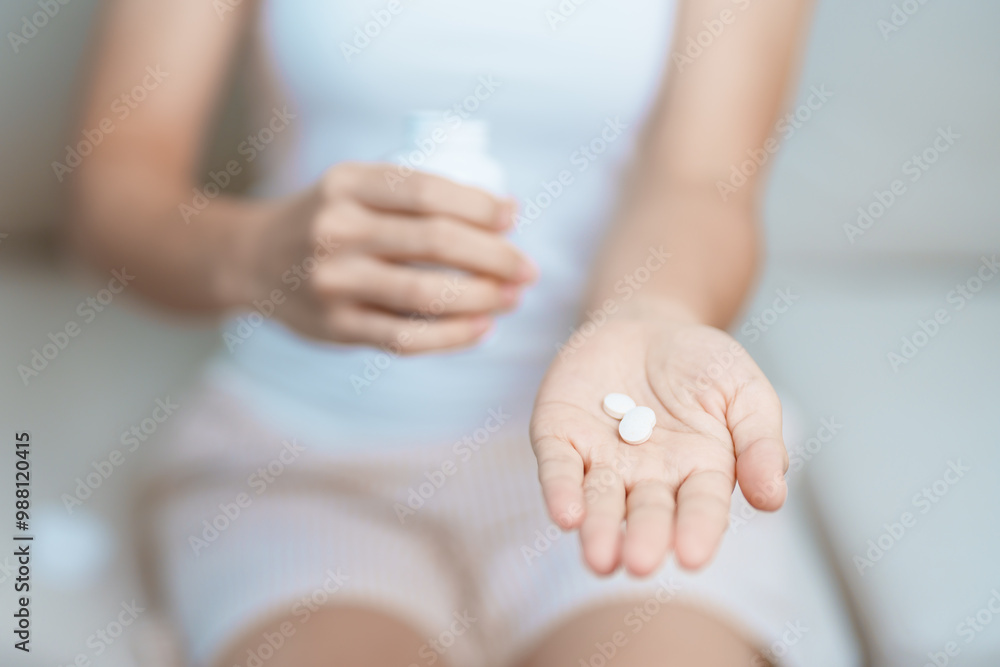 woman hand holding medicine painkiller pill on the sofa at home, taking for headaches, stomach ache, Diarrhea Pain from food poisoning, Endometriosis, Hysterectomy and Menstrual woman hand holding medicine painkiller pill on the sofa at home, taking for headaches, stomach ache, Diarrhea Pain from food poisoning, Endometriosis, Hysterectomy and Menstrual