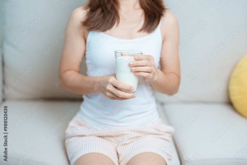 Milk drink and Daily Routine concept. Young woman Drinking milk with high calcium and nutrition at home, woman holding soy milk on glass with protein. Healthy, wellness and happy lifestyle Milk drink and Daily Routine concept. Young woman Drinking milk with high calcium and nutrition at home, woman holding soy milk on glass with protein. Healthy, wellness and happy lifestyle