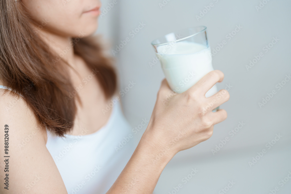 Milk drink and Daily Routine concept. Young woman Drinking milk with high calcium and nutrition at home, woman holding soy milk on glass with protein. Healthy, wellness and happy lifestyle Milk drink and Daily Routine concept. Young woman Drinking milk with high calcium and nutrition at home, woman holding soy milk on glass with protein. Healthy, wellness and happy lifestyle
