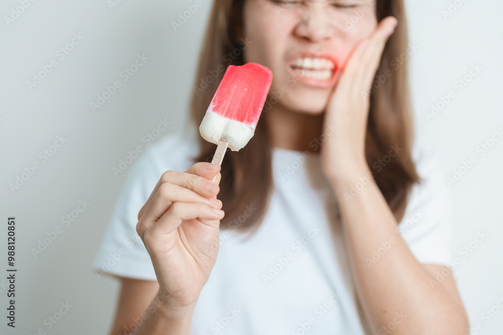 Teeth Sensitive to Cold concept. woman hold Ice cream and having toothache and pain after eat. Tooth Decay or Gum Disease, Grinding Teeth and Stress, Exposed Nerve Roots, Crack and Receding Gums Teeth Sensitive to Cold concept. woman hold Ice cream and having toothache and pain after eat. Tooth Decay or Gum Disease, Grinding Teeth and Stress, Exposed Nerve Roots, Crack and Receding Gums