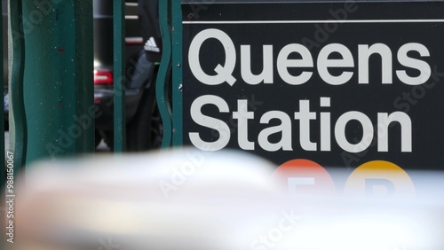 New York subway sign, Queens underground metro station. Metropolitan entrance fence, public transport exit. Long Island city street, NYC United States. Navigation text on signboard. Passenger guidance