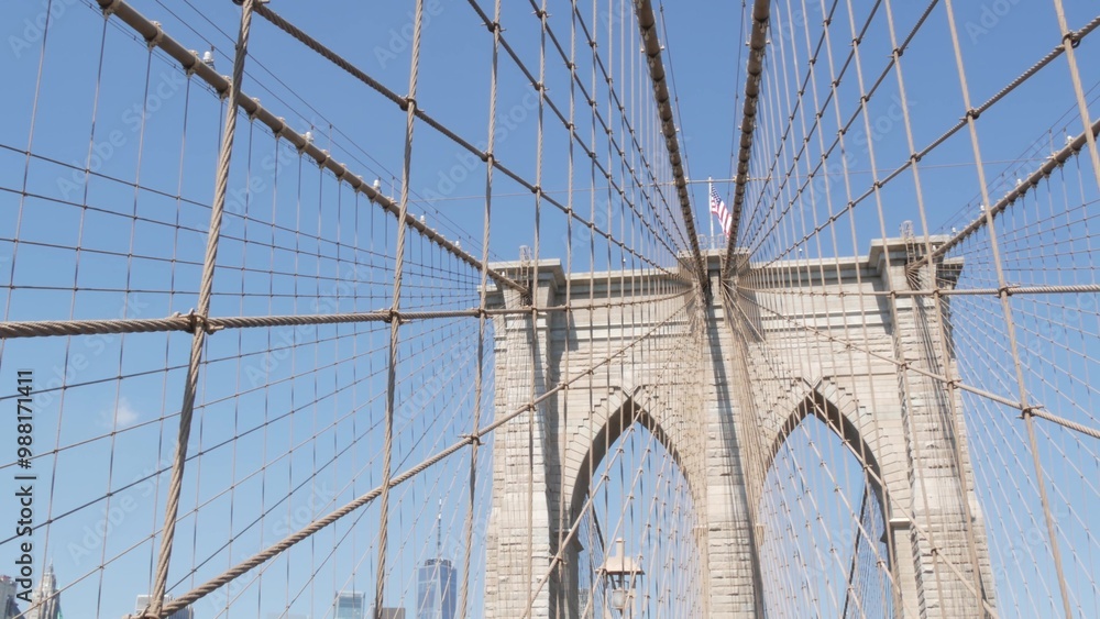 Fototapeta premium Brooklyn Bridge to Manhattan downtown, cables and blue sky. New York City iconic symbol, USA travel destination. Architecture of United States of America, tourist landmark. Famous cable-stayed bridge.