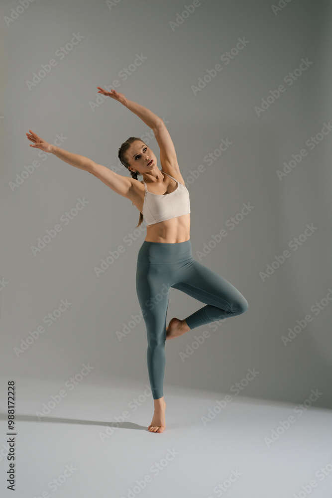 Graceful dancer performing an elegant pose in studio during a dance session Graceful dancer performing an elegant pose in studio during a dance session