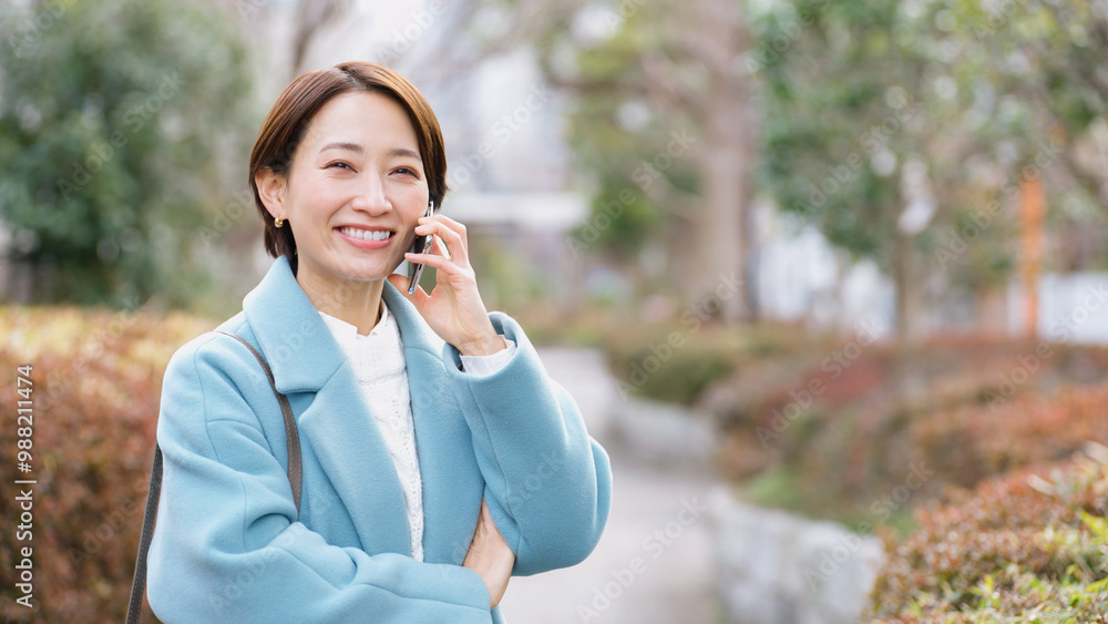 スマホで話す女性（冬服・上着・コート）