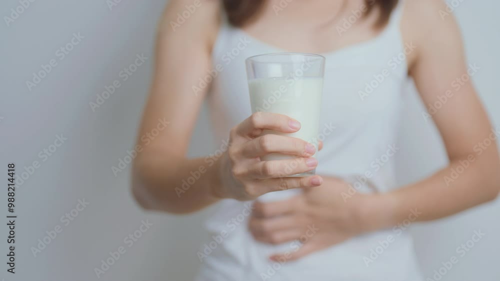 Lactose intolerance and Milk allergy concept. woman hold Milk glass and having abdominal cramps and pain when drink Cow Milk. Symptom stomach ache, Dairy intolerant, Nausea, Bloating, Gas and Diarrhea Lactose intolerance and Milk allergy concept. woman hold Milk glass and having abdominal cramps and pain when drink Cow Milk. Symptom stomach ache, Dairy intolerant, Nausea, Bloating, Gas and Diarrhea