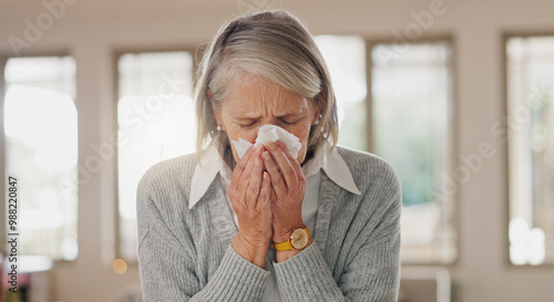 Senior woman, tissue and blowing nose in home, sick and retirement with flu, cold or sinus in morning. Elderly person, paper and cleaning for hygiene, allergies or sneeze with hay fever at apartment photo