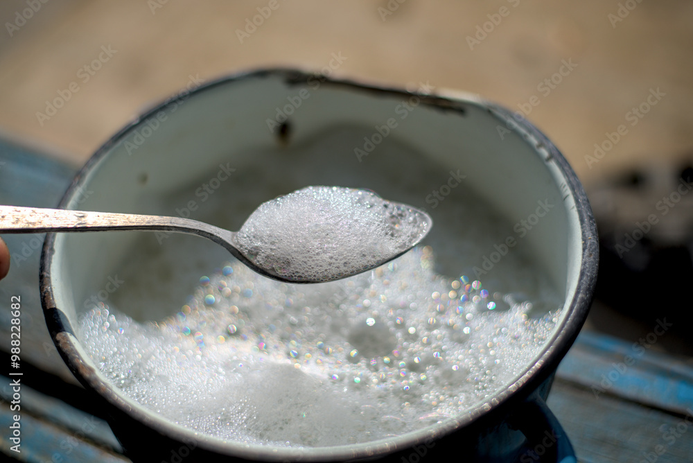 Metal spoon with foam from washing powder