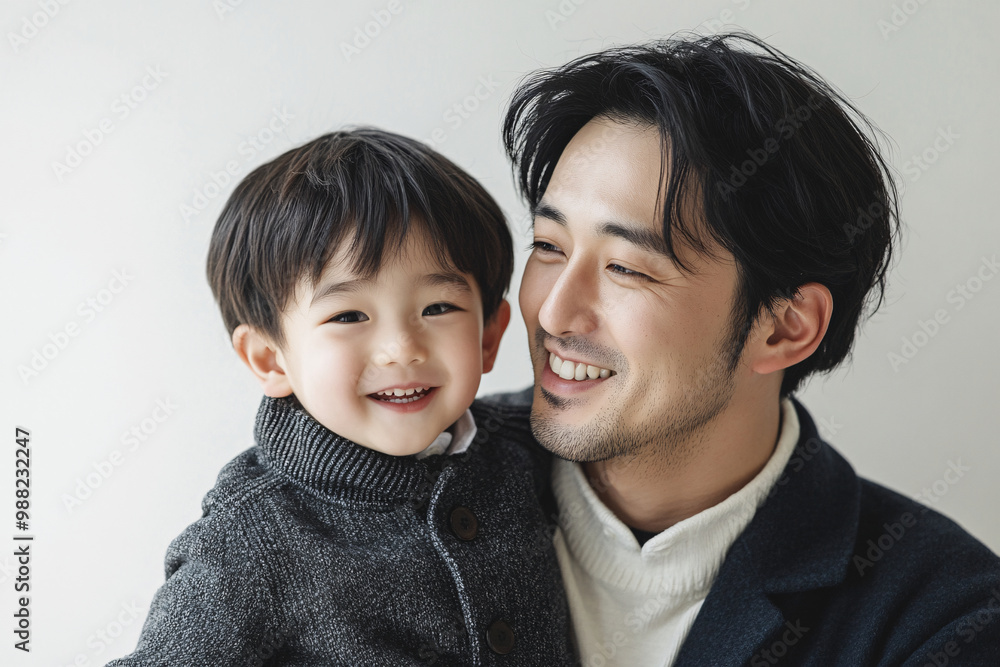 Loving father and young son smiling and sharing joyful moments, either looking at each other or at the camera, in a cozy white studio setting, capturing heartwarming family interactions. Loving father and young son smiling and sharing joyful moments, either looking at each other or at the camera, in a cozy white studio setting, capturing heartwarming family interactions.