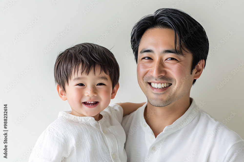 Loving father and young son smiling and sharing joyful moments, either looking at each other or at the camera, in a cozy white studio setting, capturing heartwarming family interactions. Loving father and young son smiling and sharing joyful moments, either looking at each other or at the camera, in a cozy white studio setting, capturing heartwarming family interactions.