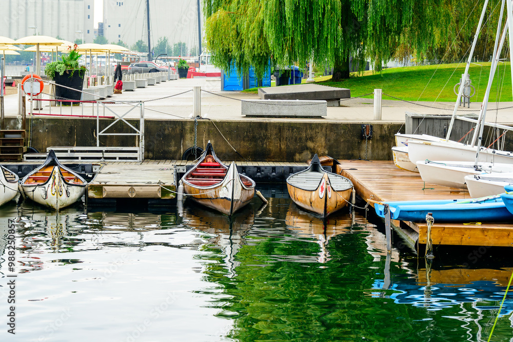 Obraz premium voyageur canoes in urban harbor shot downtown toronto in fall with city park in background