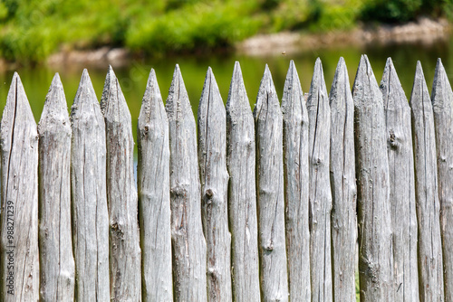 A wooden fence with a green background