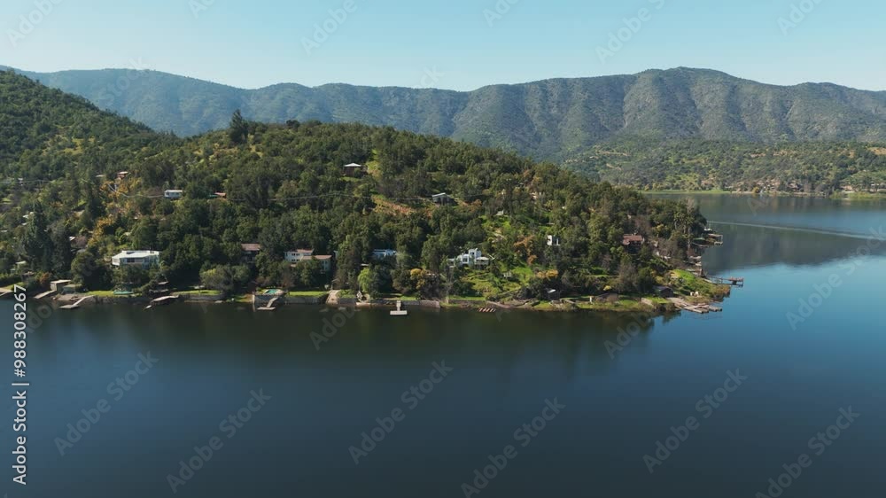 Aerial view of Aculeo Lagoon in Chile, surrounded by scenic mountains and lush greenery. Dolly Right Shot Aerial view of Aculeo Lagoon in Chile, surrounded by scenic mountains and lush greenery. Dolly Right Shot