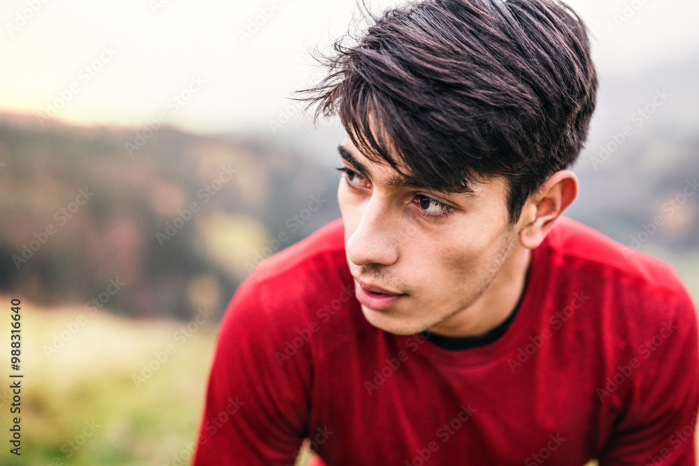 Portrait of male runner resting after jog in nature, enjoying view on autumn landscape. Morning running training for young man. Portrait of male runner resting after jog in nature, enjoying view on autumn landscape. Morning running training for young man.