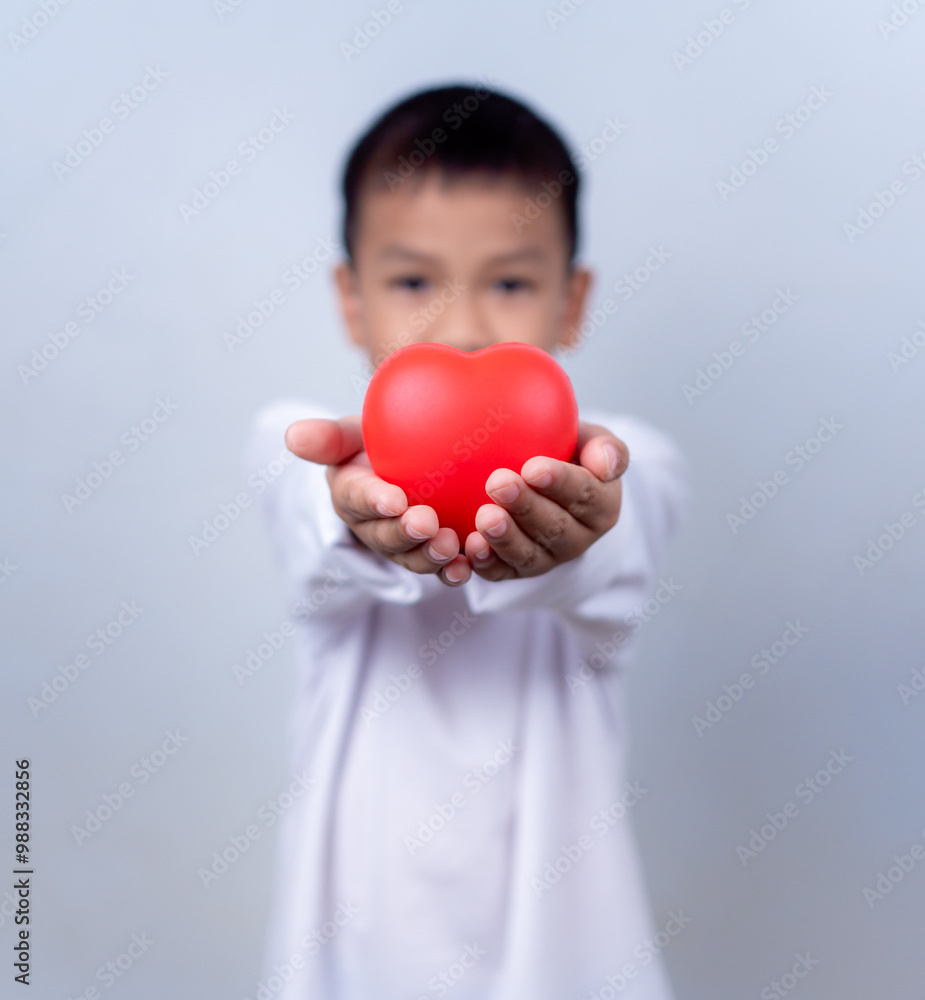 Portrait of Asian little boy child holding red heart sign on white background. Portrait of Asian little boy child holding red heart sign on white background.