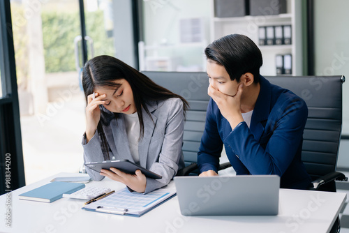 Furious two Asian businesspeople arguing strongly after making a mistake at work in office. photo