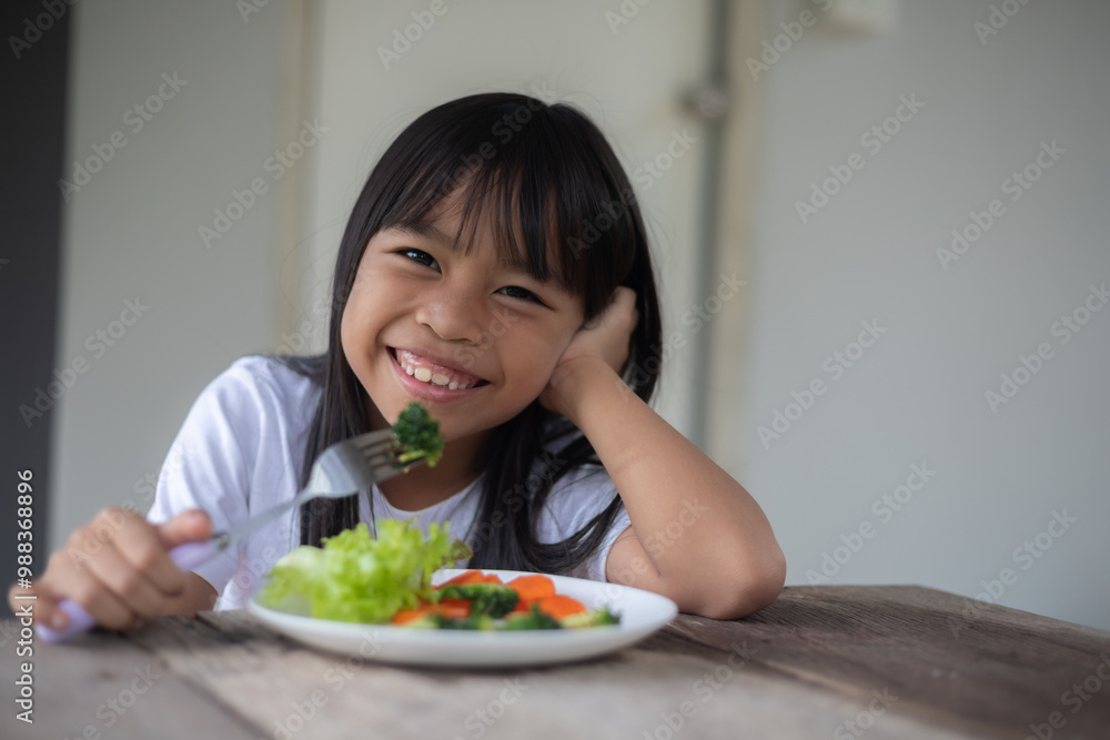 A young girl is eating a plate of vegetables, including broccoli and carrots A young girl is eating a plate of vegetables, including broccoli and carrots