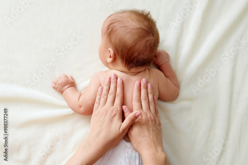 Chiropractic manual therapist manipulating child's back baby girl receiving massage therapy ensuring his delicate muscles receive proper care and relaxing treatment at home