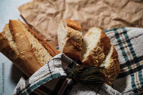 french baguette fresh, cut in slices, in kitchen textile cloth, rustic sryle photo