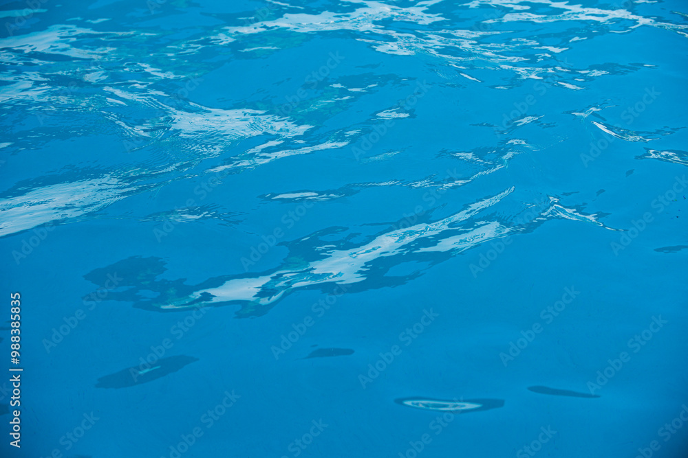 Fototapeta premium Blue pool water background. Blurred transparent clear calm water surface texture. Water waves in sunlight with copy space.