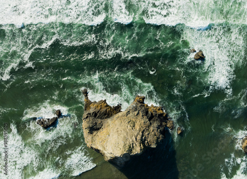 Canvas-taulu A rocky shoreline with a large rock in the middle