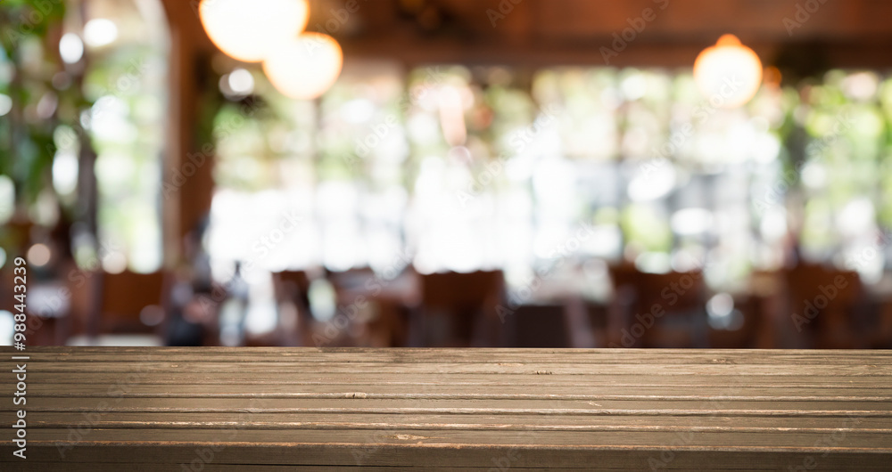 A wooden table top with a blurred background of a restaurant interior. A wooden table top with a blurred background of a restaurant interior.