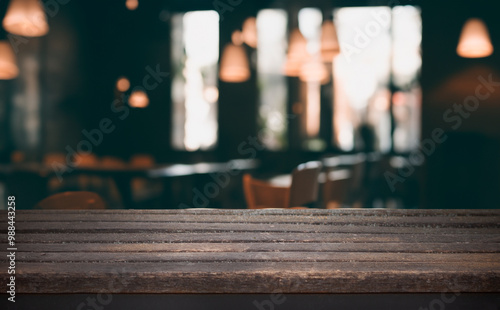 A close-up of a rustic wooden table top with a blurred cafe background.