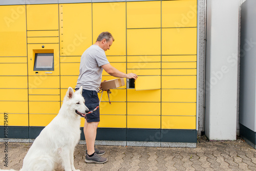 Man with white dog collecting parcel from terminal photo