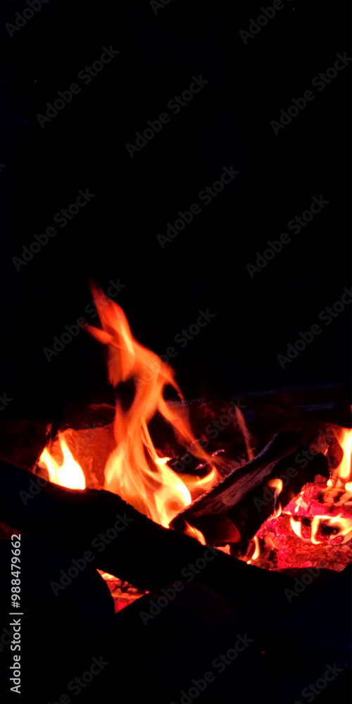 Outdoor campfire. Campfire for cooking food on a camping trip. Fire on a black background. Vertical photo Outdoor campfire. Campfire for cooking food on a camping trip. Fire on a black background. Vertical photo