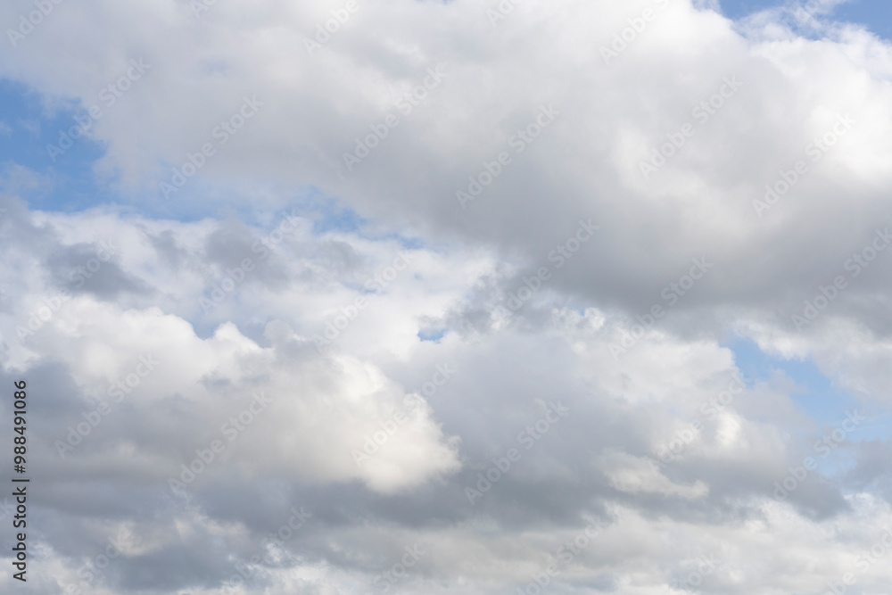 Fluffy white clouds, against a bright blue sky, with little editing.
