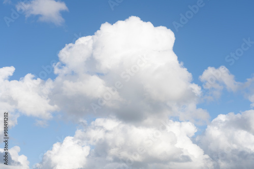 Fluffy white clouds, against a bright blue sky, with little editing.