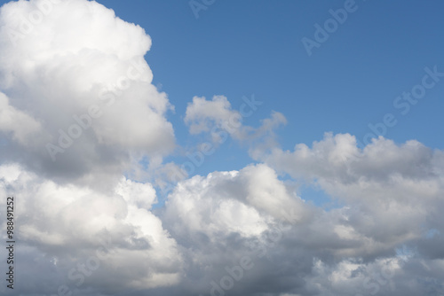 Fluffy white clouds, against a bright blue sky, with little editing.