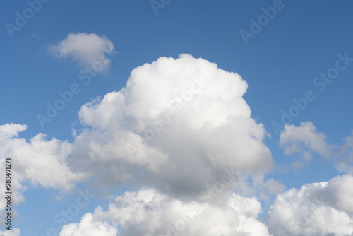 Fluffy white clouds, against a bright blue sky, with little editing.