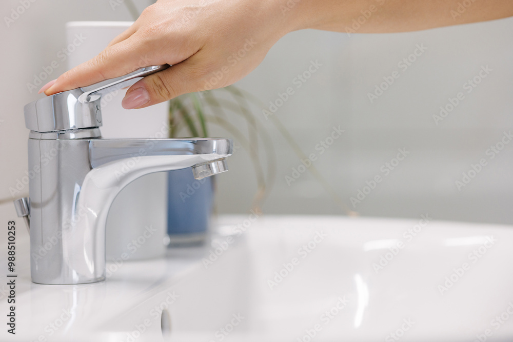 The woman tries to turn on the water in the bathtub, but no water comes out The woman tries to turn on the water in the bathtub, but no water comes out