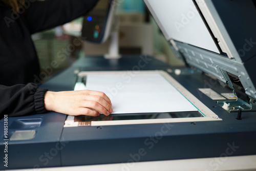 Woman operating printing machine at press