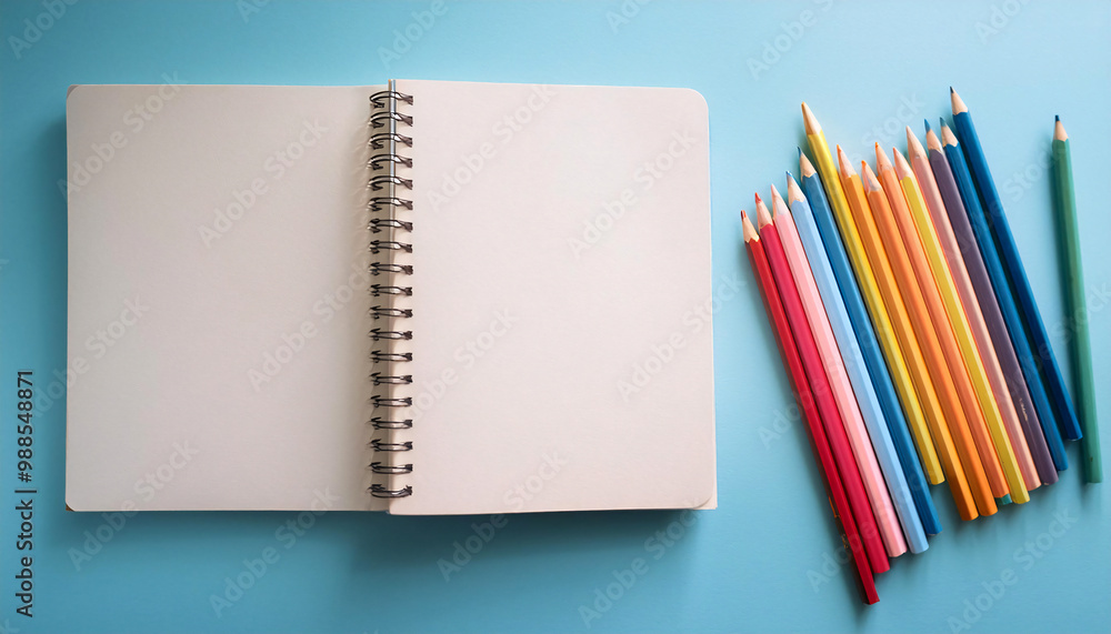 Sketchbook and Colored Pencils on a Soft Pastel Blue Background Sketchbook and Colored Pencils on a Soft Pastel Blue Background