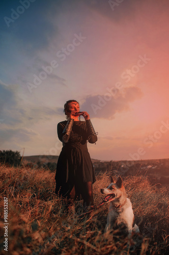 Beautiful girl in gothic style clothes with tattoo on her face plays ocarina in the mountains