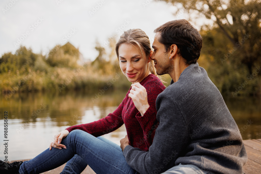 Young man hugging girlfriend on pier near lake Young man hugging girlfriend on pier near lake
