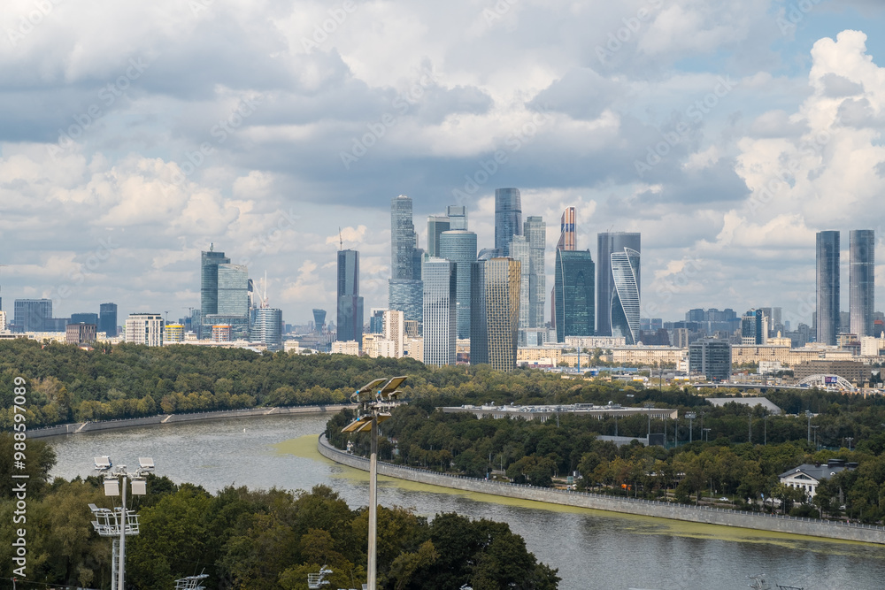 A breathtaking view of the modern Moscow City skyline framed by lush parkland and the winding river, creating a peaceful urban escape