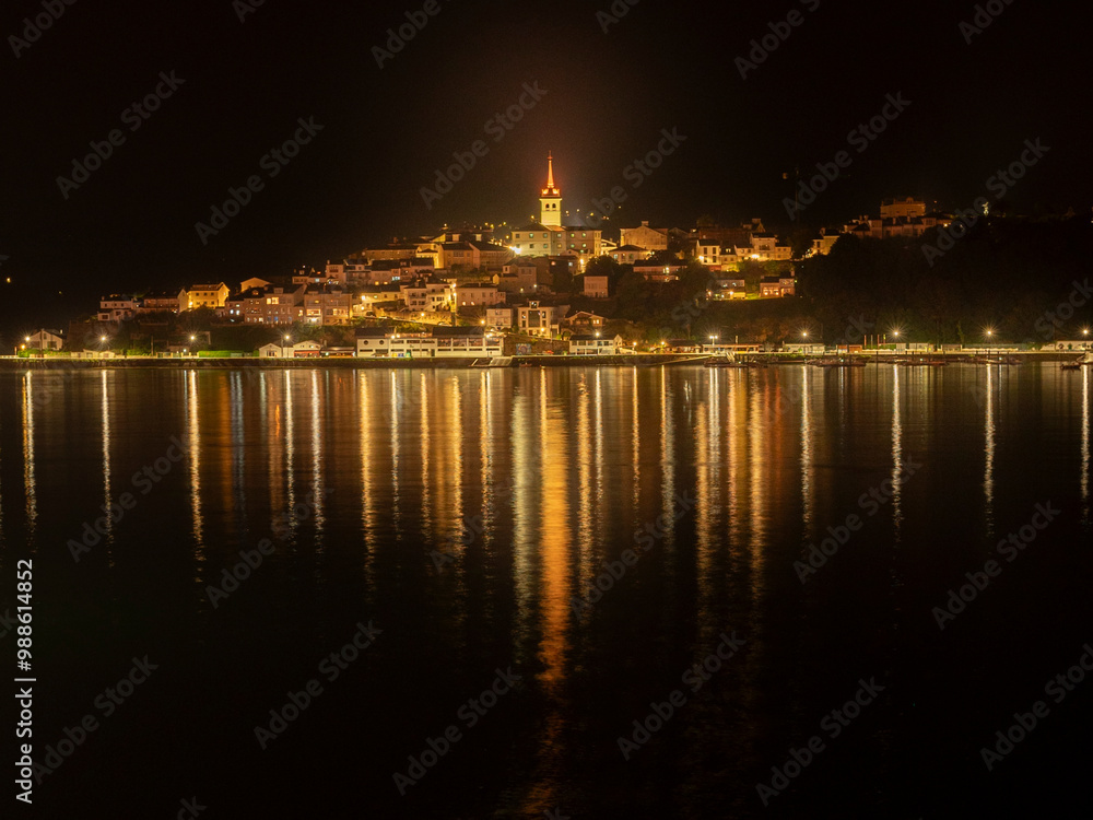 Fototapeta premium Historic Church Tower Dominates the Skyline of a Seaside Village