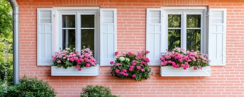 Suburban house with a classic red brick exterior, white trim, and flower-filled window boxes