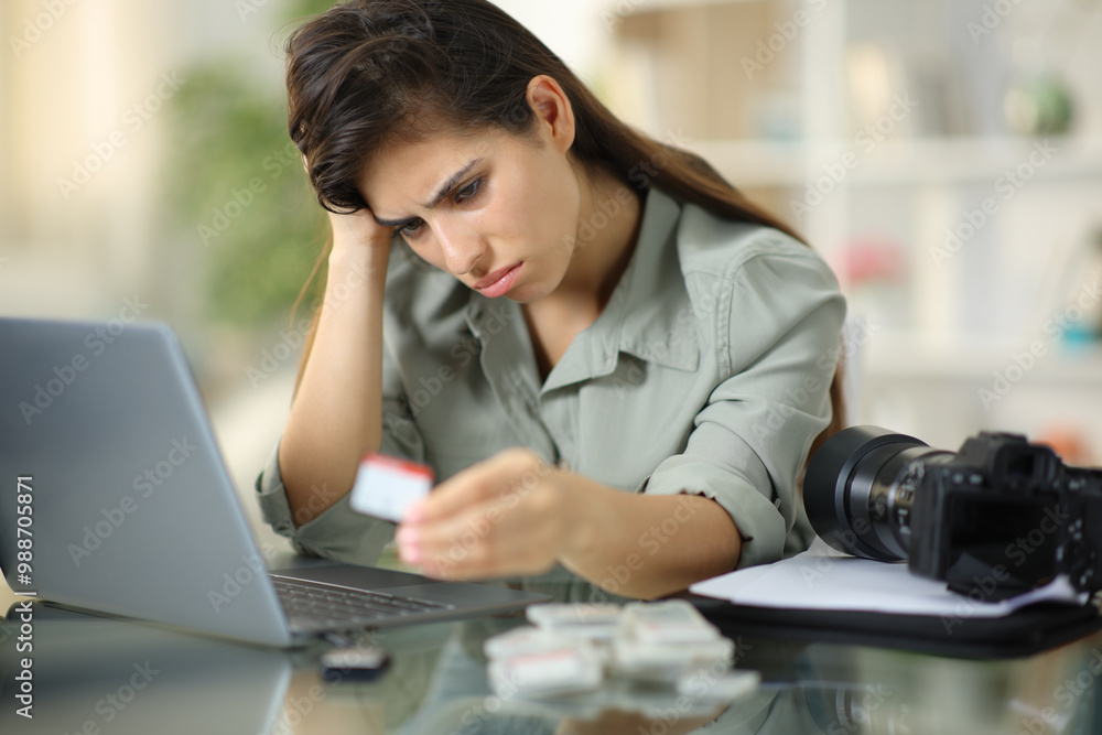 Sad photographer looking at memory card after data loss Sad photographer looking at memory card after data loss