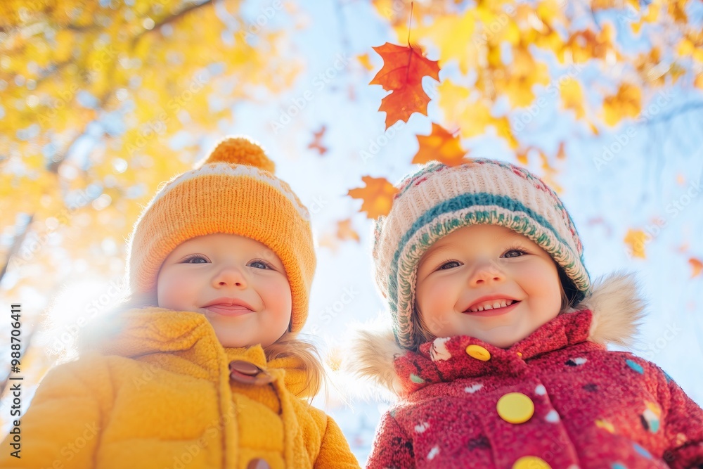 two toddlers wearing modern warm autumn clothes with autumn leaves levitating pattern, colorful autumn forest in the background
