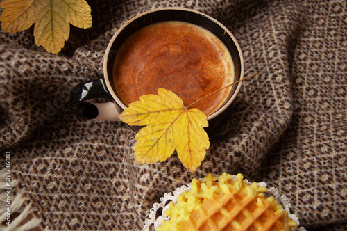 Cozy autumn coffee with leaves and a blanket